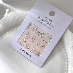 Nail art stickers set with blue rhinestones and silver star moon charms on white tray