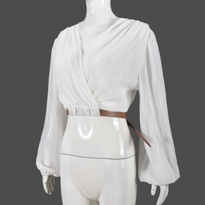 Detailed shot of white pleated shirt texture and contrast brown leather waist belt