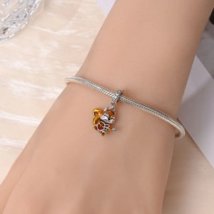 Detailed shot of a silver squirrel guitar charm with enamel on a beaded bracelet