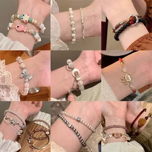 Close-up of pearl bracelets and beaded jewelry collection with various charms in 3x3 grid