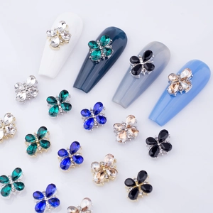 Flower-shaped nail art charms with colorful teardrop gems and metallic floral base