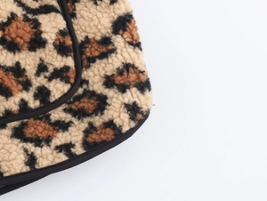 Detailed close-up showing leopard print fleece fabric texture with black stitched edges