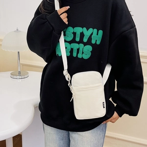 Minimalist white crossbody bag with adjustable strap and front pocket for casual travel