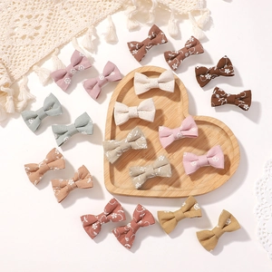 Detailed flat lay of handmade cotton bow hair clips in various Morandi colors and patterns