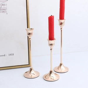 Set of three Nordic gold brass candlesticks with elegant slim stems and stable bases