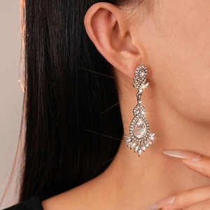 Close-up of sparkling crystal teardrop earrings worn by a model in a luxury style