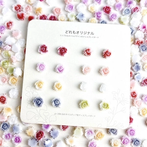 3D resin rose charms for DIY nail art in various pastel colors on a display card