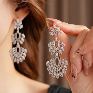 Gros plan de boucles d'oreilles vintage en argent avec fleurs en zircone et perles