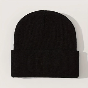 Detailed macro view of the fine knitting texture on a black cuffed winter beanie hat