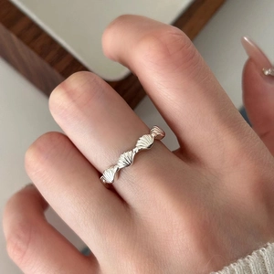 Detailansicht eines S925 Silberrings mit Muschelmuster an einem Finger getragen