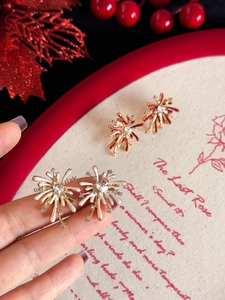 Detailed macro view of sparkler stud earrings with cream and burgundy enamel details