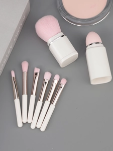 Detailed close-up of 8-in-1 ivory and pink makeup brush set with synthetic bristles