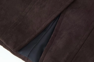 Gros plan sur le tissu en daim marron foncé avec coutures précises et doublure noire