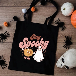 Halloween Stay Spooky black canvas tote bag with cartoon ghost and pumpkin illustration