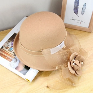 Détail du chapeau en feutre de laine camel avec nœud en résille et fleur de perles
