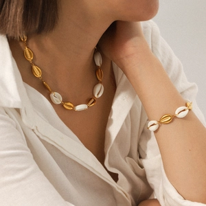 Close-up of bohemian gold stainless steel shell necklace and bracelet set on a model