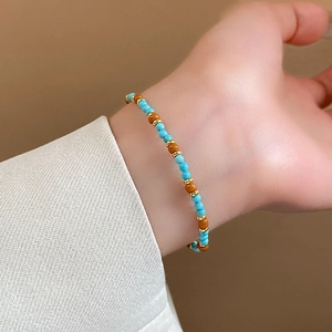 Gros plan détaillé du bracelet tressé à la main avec perles colorées et grelots dorés