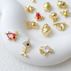 Macro shot of 14k gold plated marine charms like starfish and shells with red zircons