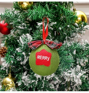 Detailed shot of green knit Christmas ball with red star patch and Merry embroidery