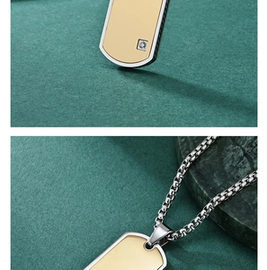 Detailed view of dual-tone silver and gold military tag pendant with small diamond inlay