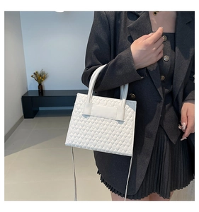 Detailed macro view of white quilted tote bag featuring embossed rhombus diamond texture