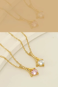 Close-up of gold necklaces featuring geometric pendants with pink and white cubic zirconia
