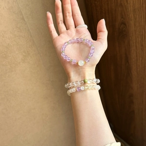Natural amethyst and green stone beaded bracelet with elegant gold accents on wrist