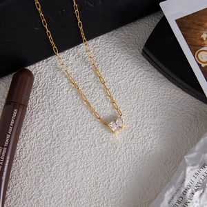 Detailed close-up of a 18K gold stainless steel chain with a double zircon pendant
