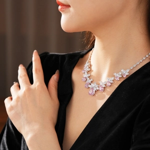 Détail d'un collier argenté avec gouttes roses et zircons marquises portés par un mannequin