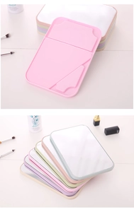 Detail view of foldable tabletop makeup mirrors in pastel colors for dorm vanity