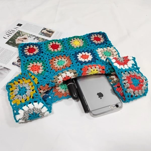 Close-up of handmade crochet floral bag with colorful knit patterns and woven texture