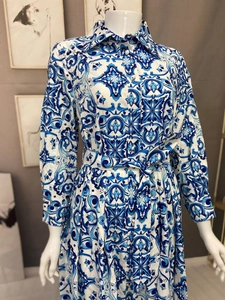 Detailed view of the blue and white porcelain tile print and waist tie belt on the dress