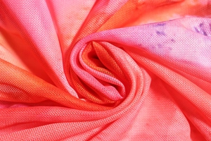 Gros plan d'un tissu en maille respirant avec un dégradé de rose et d'orange doux