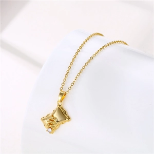 Macro view of gold pillow-shaped dollar sign pendant with a sparkling zircon stone