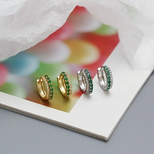 Detailed macro view of S925 silver huggie earrings with green and white double row zircon
