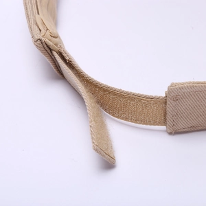 Détail de la sangle réglable en velcro sur la visière beige pour un ajustement idéal