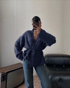 Dettaglio elegante cardigan in maglia blu scuro con cintura annodabile e maniche lunghe