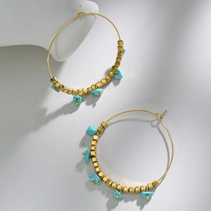 Detailed shot of 14k gold hoop earrings with turquoise stones and gold square beads