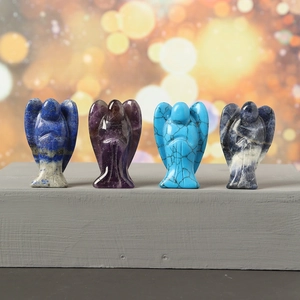 Detail view of crystal angels carved from amethyst, lapis lazuli and sodalite on a stand