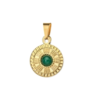 Close-up of golden stainless steel pendant with green gemstone and sunburst texture