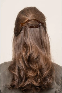 Detail view of large tortoiseshell hair claw clip securing a hair bun on model