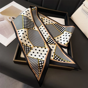 Detailed view of polka dot and stripe silk-style scarf with elegant gold line accents