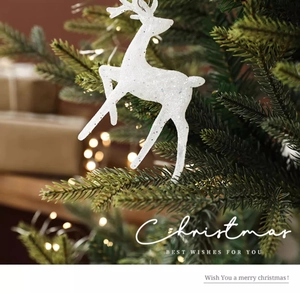 Détail d'un renne de Noël blanc pailleté sur fond flou de sapin décoré et lumières chaudes
