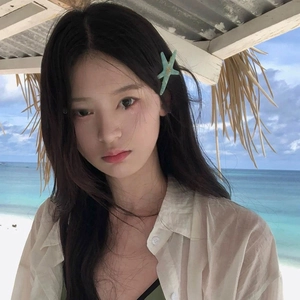Mint green starfish acrylic hair clip worn on model with beach resort background