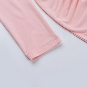 Détail de la couture des poignets et de la texture en maille de cette robe rose