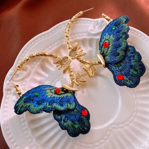 Vintage gold hoop earrings with blue embroidered butterfly wings and small crystals