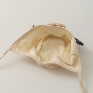 Dettaglio della fodera in cotone e dei paraorecchie del cappello da pilota neonato