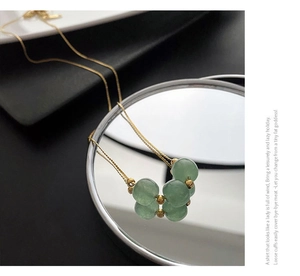 Macro shot of green bead butterfly pendant necklace with golden stainless steel chain