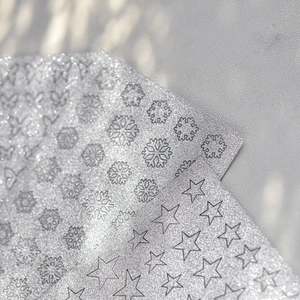 Macro view of silver glitter nail art stickers with snowflake and star patterns