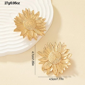 Macro view of gold sunflower leaf earrings with detailed size measurements and weight